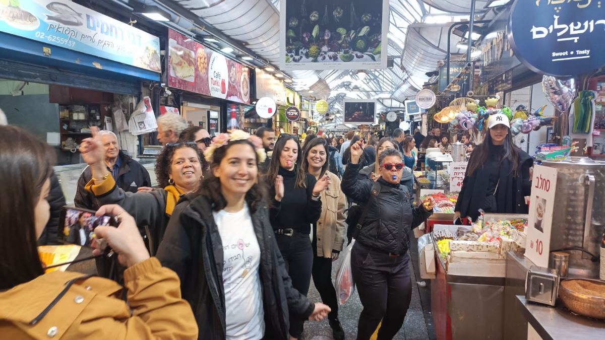 קבוצה חוגגת בשוק מחנה יהודה
